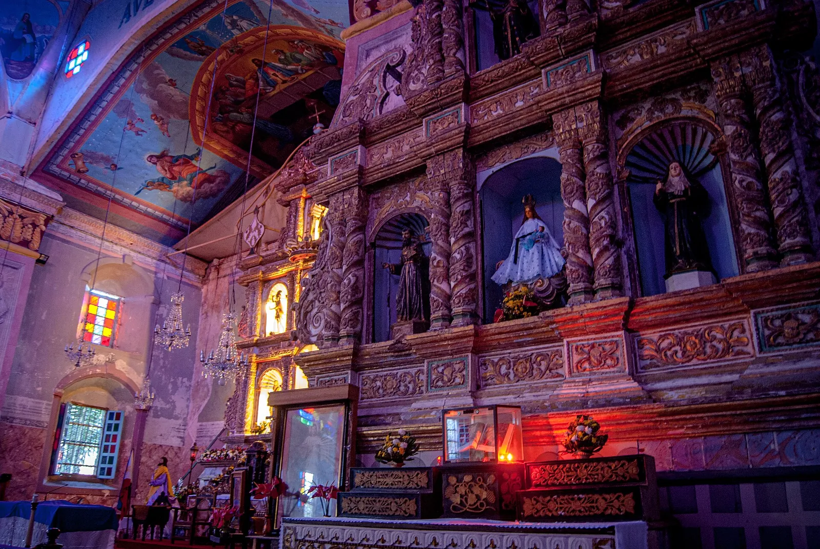 Decorated altar and painted ceiling inside Baclayon Church