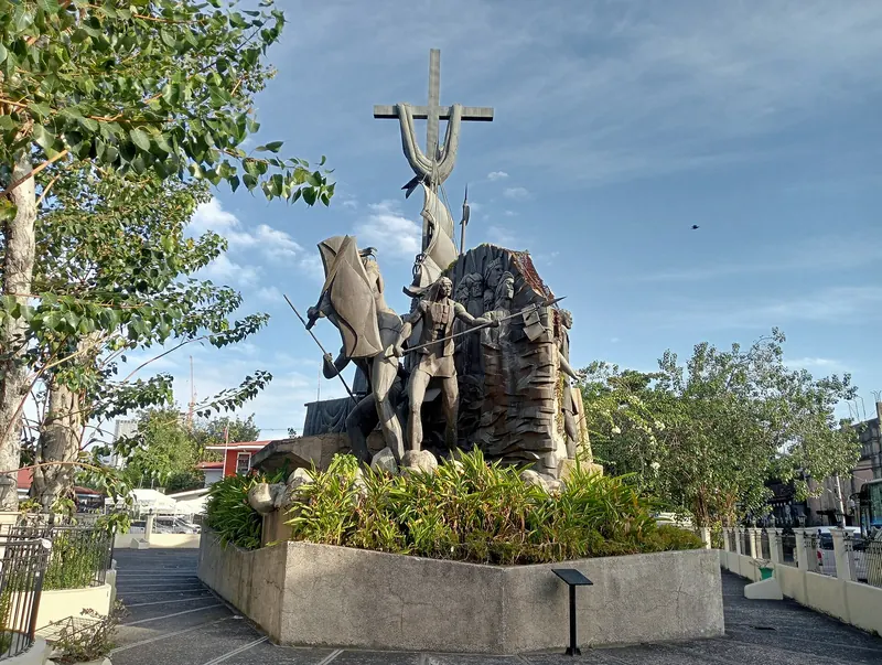 Sculptures and a cross in the landscaped Heritage of Cebu Monument