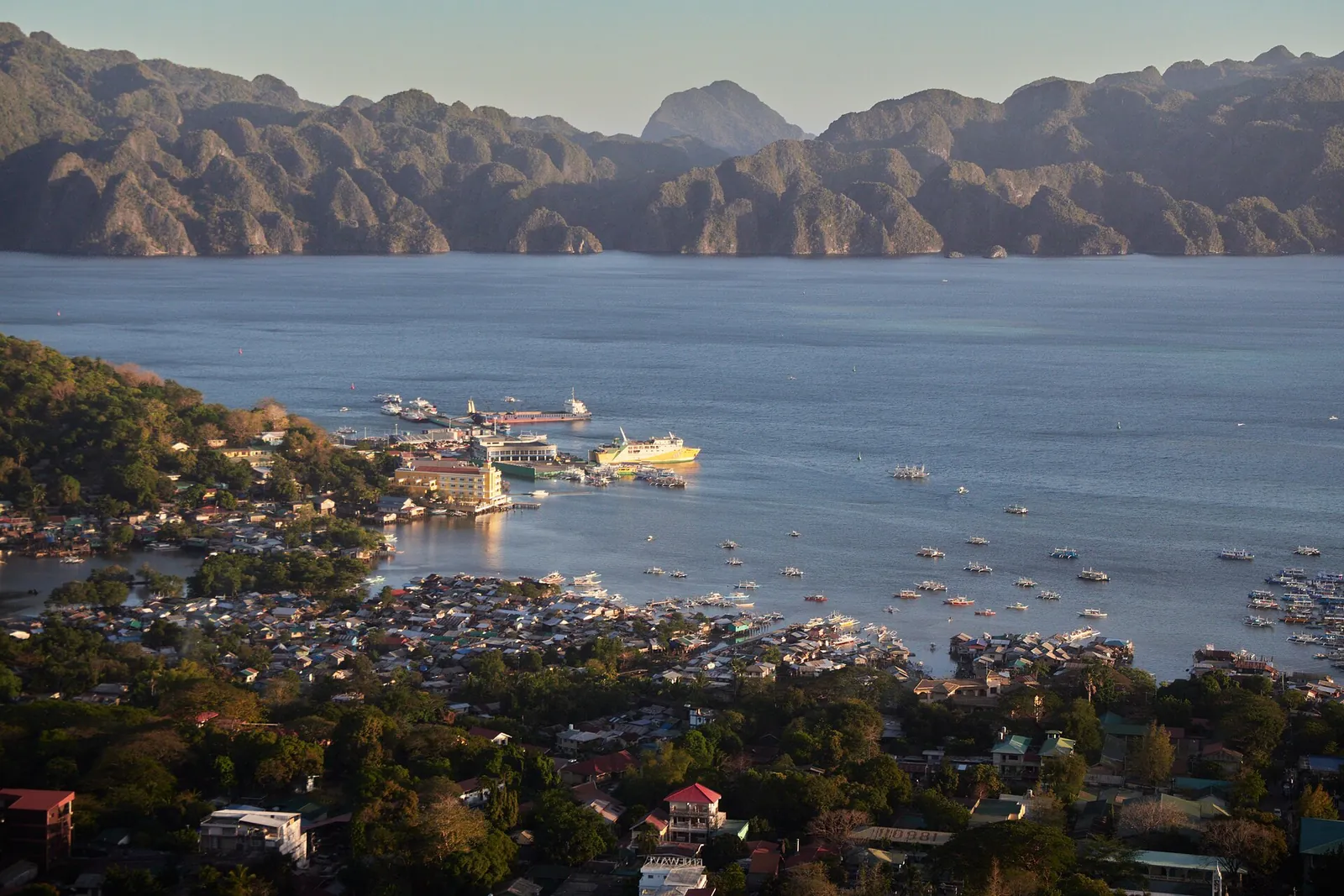 Coron town and boats on the bay beneath distant limestone mountains
