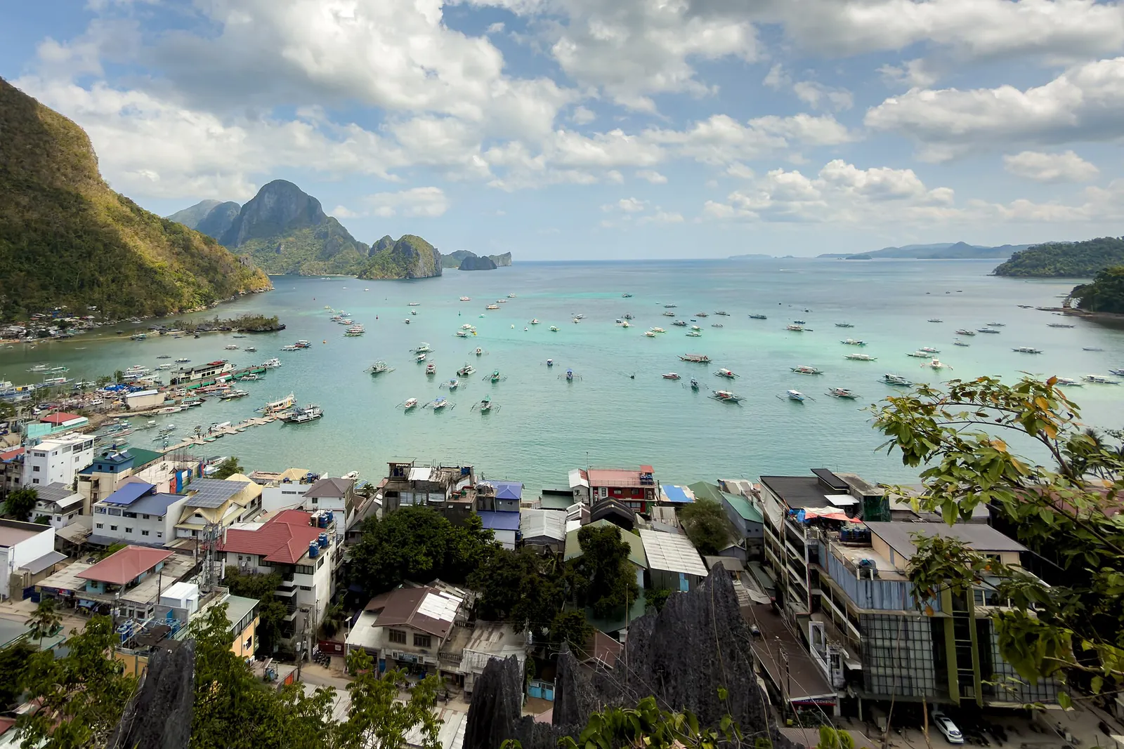Buildings and outrigger boats along El Nido Town Beach seen from above