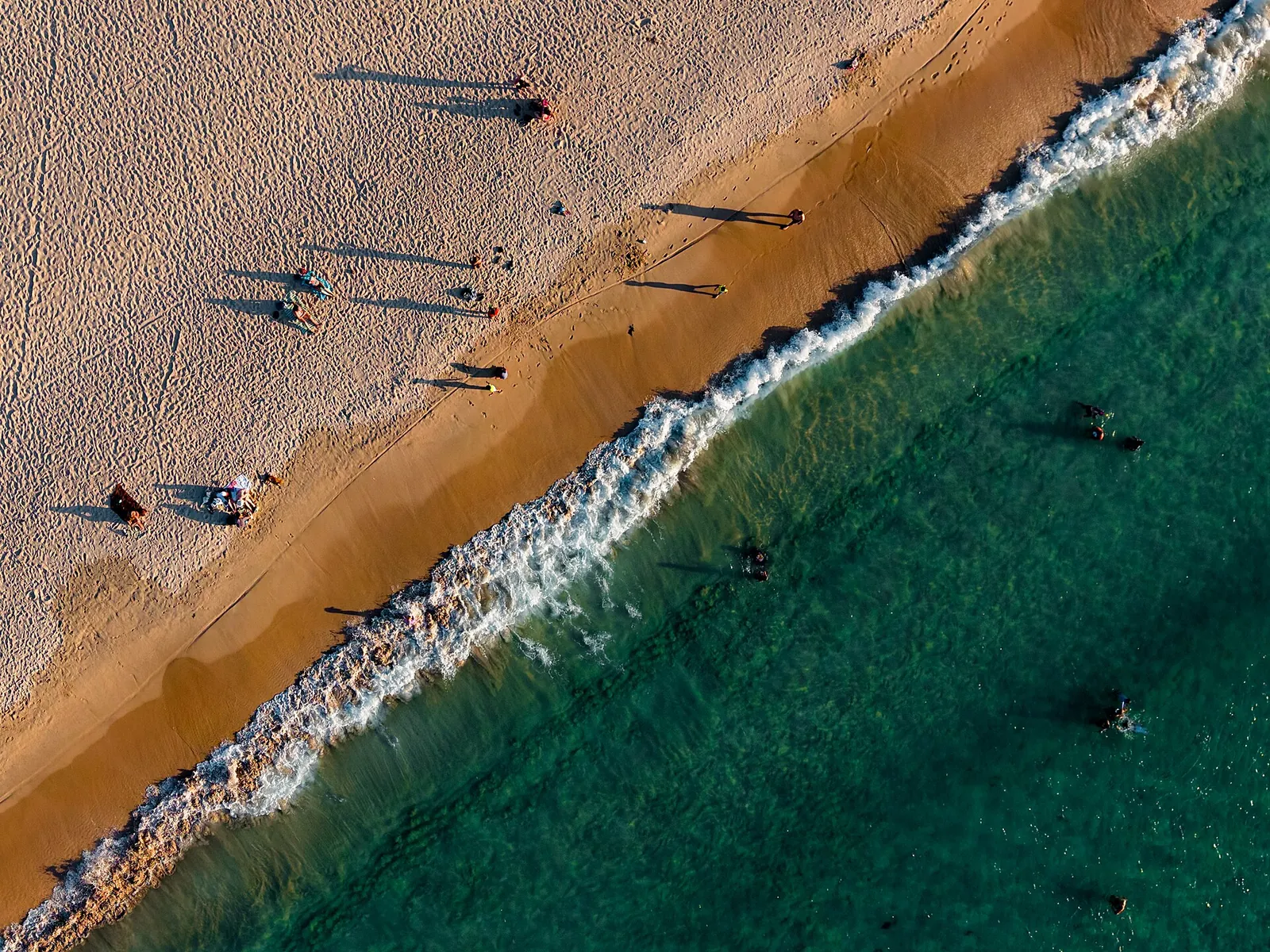 Golden sand and breaking waves seen from above Nacpan Beach