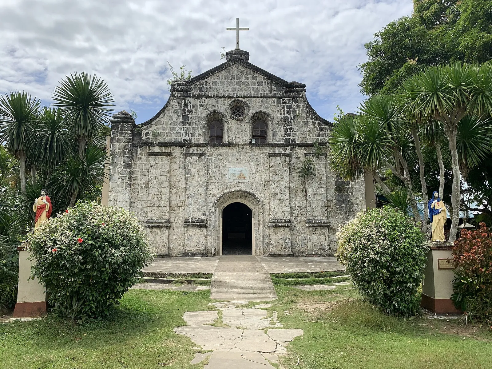 Navalas Church behind a lawn and palm trees on Guimaras
