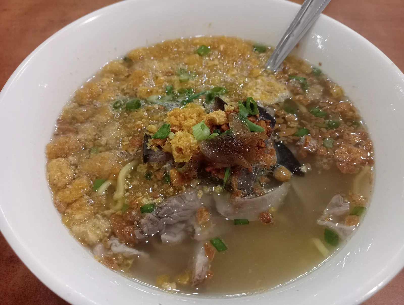 Bowl of batchoy topped with meat and crisp garnishes at La Paz Public Market in Iloilo City
