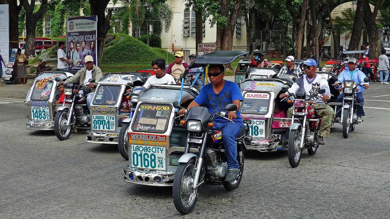 Motorised tricycles lined up on a street in Laoag