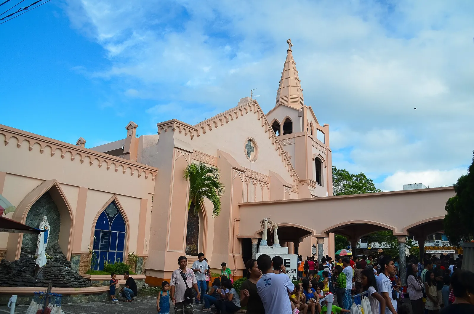 Pink facade and visitors outside Saint Raphael Parish Church in Legazpi City