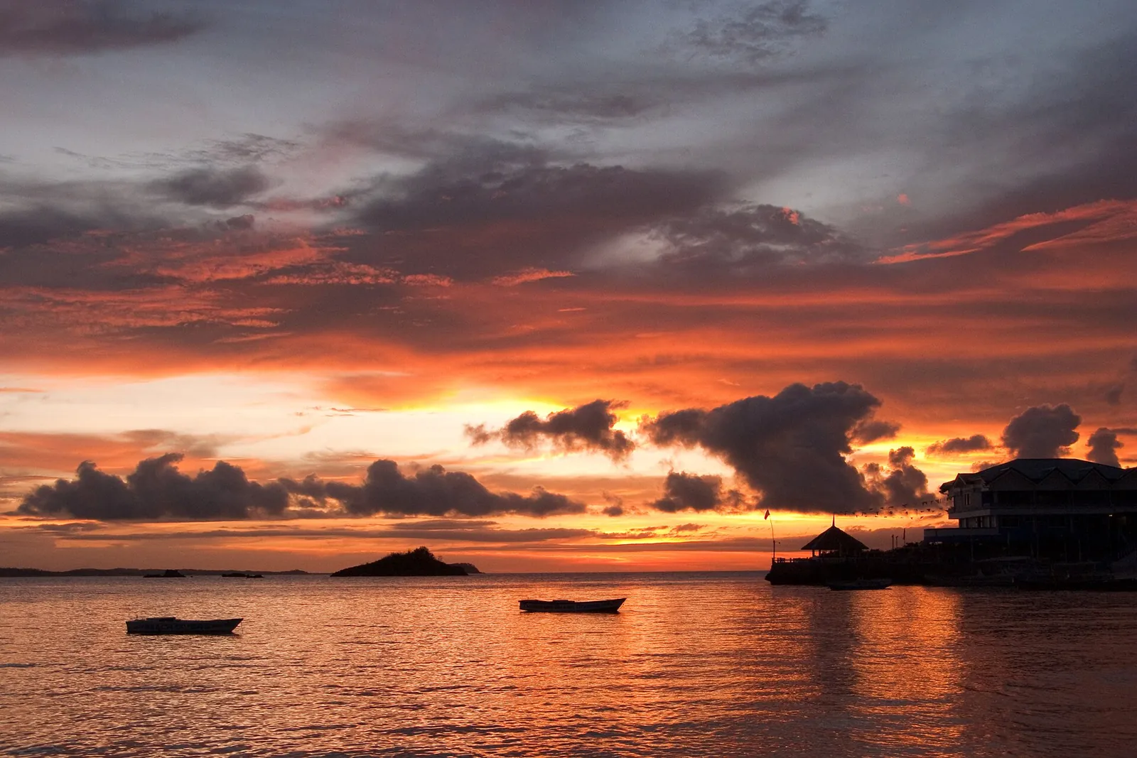 Orange sunset reflected over the sea beside Malapascua Island