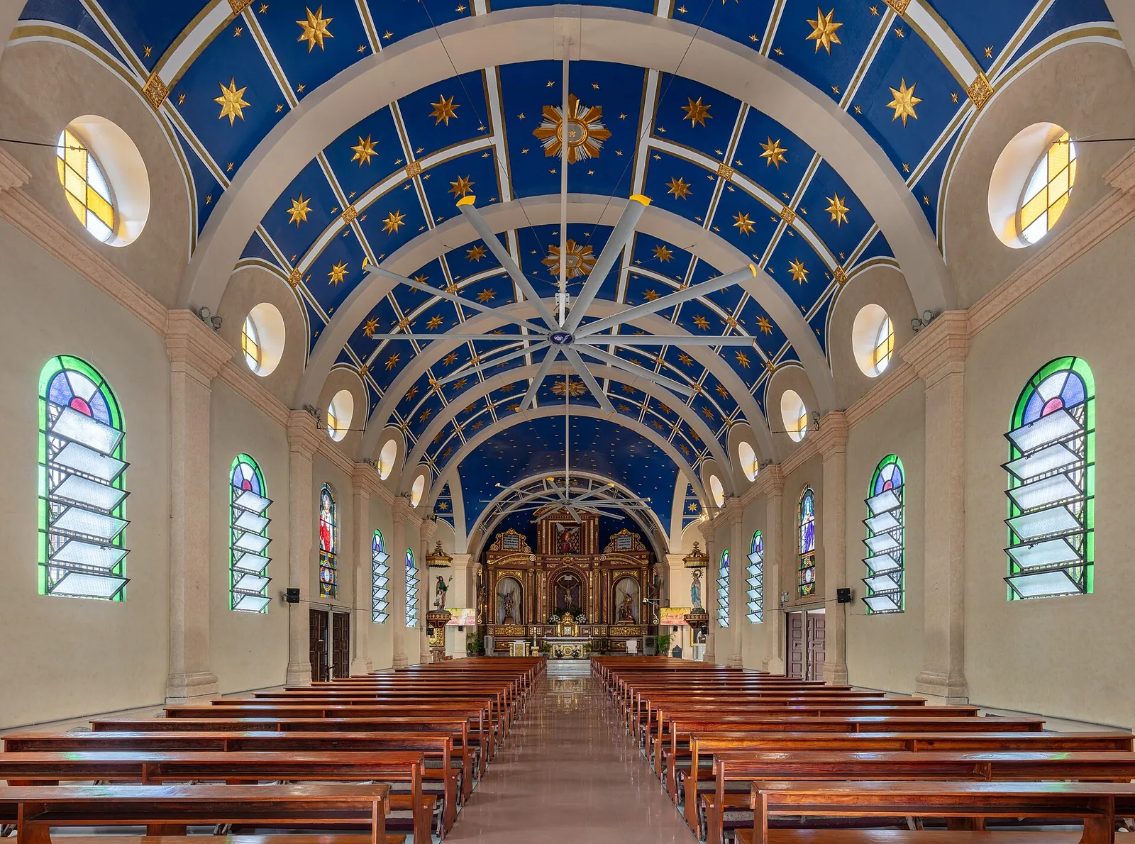 Blue vaulted ceiling and wooden pews inside San Miguel Church in Manila