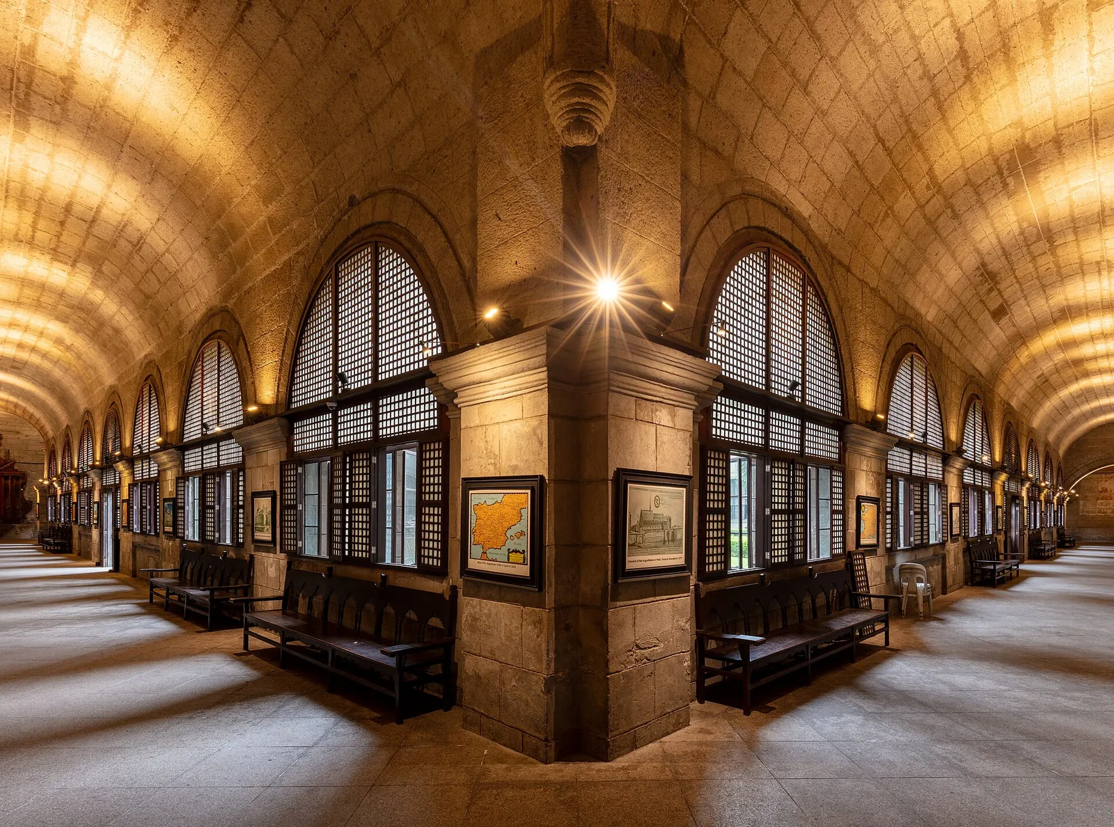 Stone arches and wooden benches in a San Agustin museum corridor in Manila