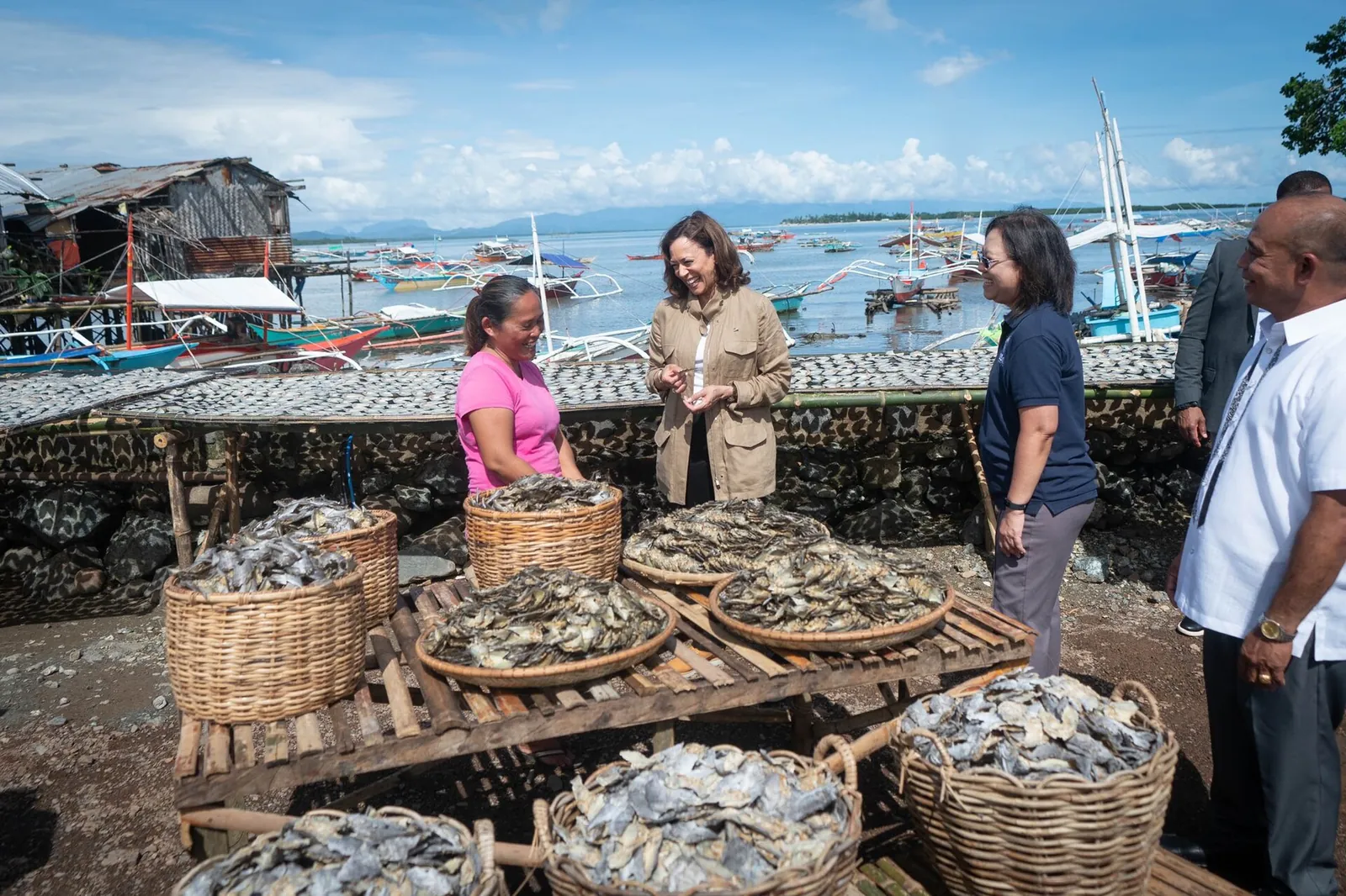 Baskets of seafood displayed beside residents and visitors in Tagburos fishing village