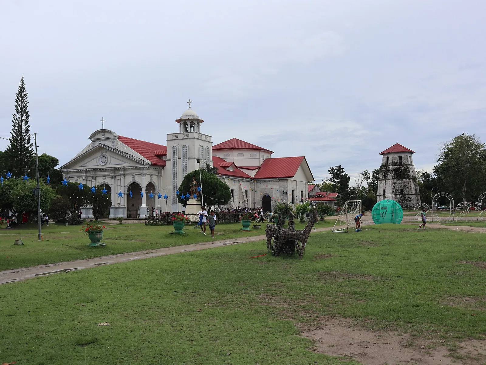 Saint Augustine Church and the old watchtower beside green lawns in Panglao town