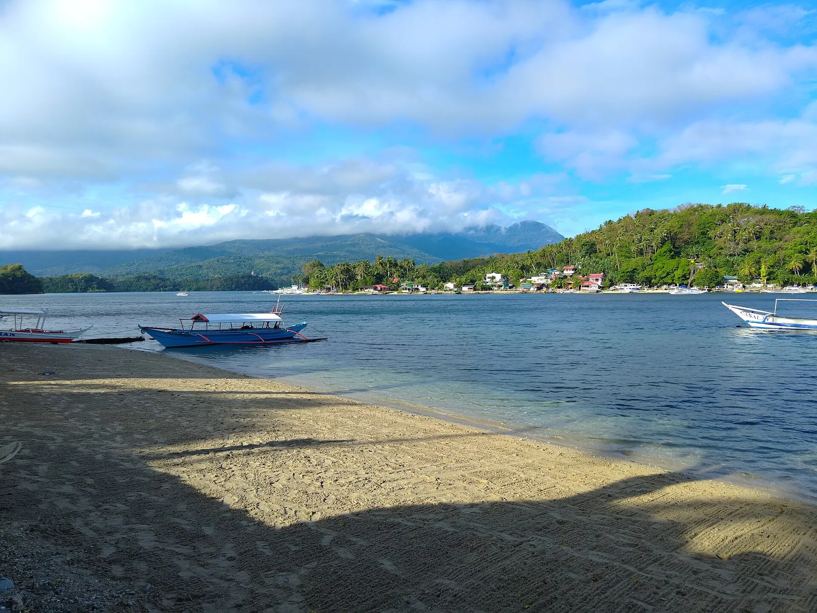 Puerto Galera Bay and a small boat viewed from the Casalay Resort beach
