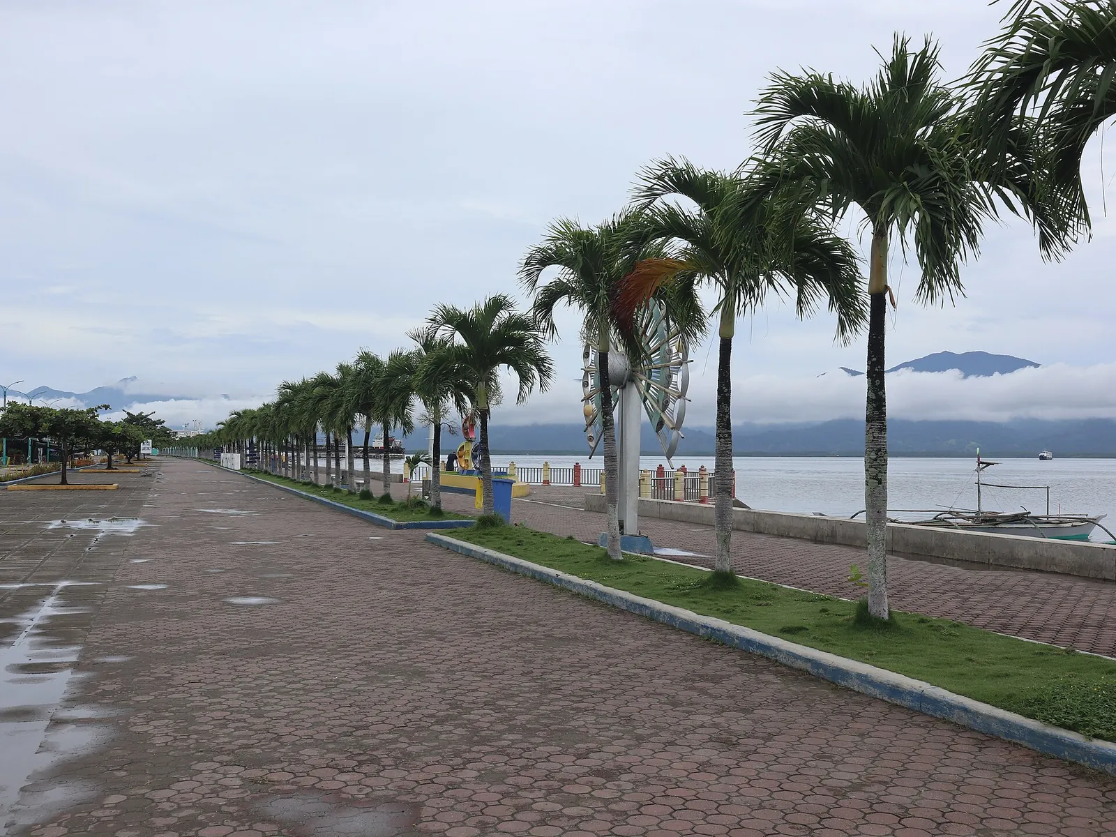 Palm-lined promenade beside the water at Puerto Princesa City Baywalk