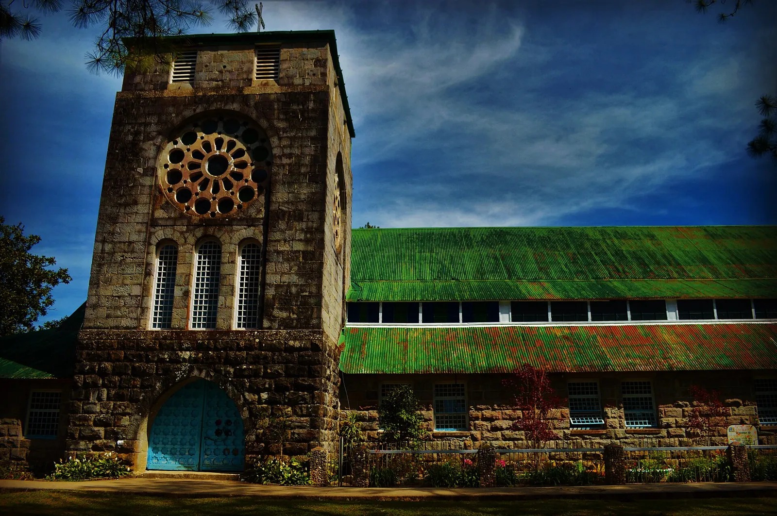 Stone church tower and green roof at Saint Mary the Virgin in Sagada