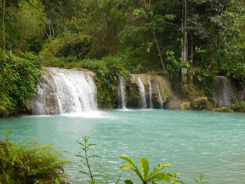 Broad waterfalls and a turquoise pool at Cambugahay Falls in Lazi on Siquijor