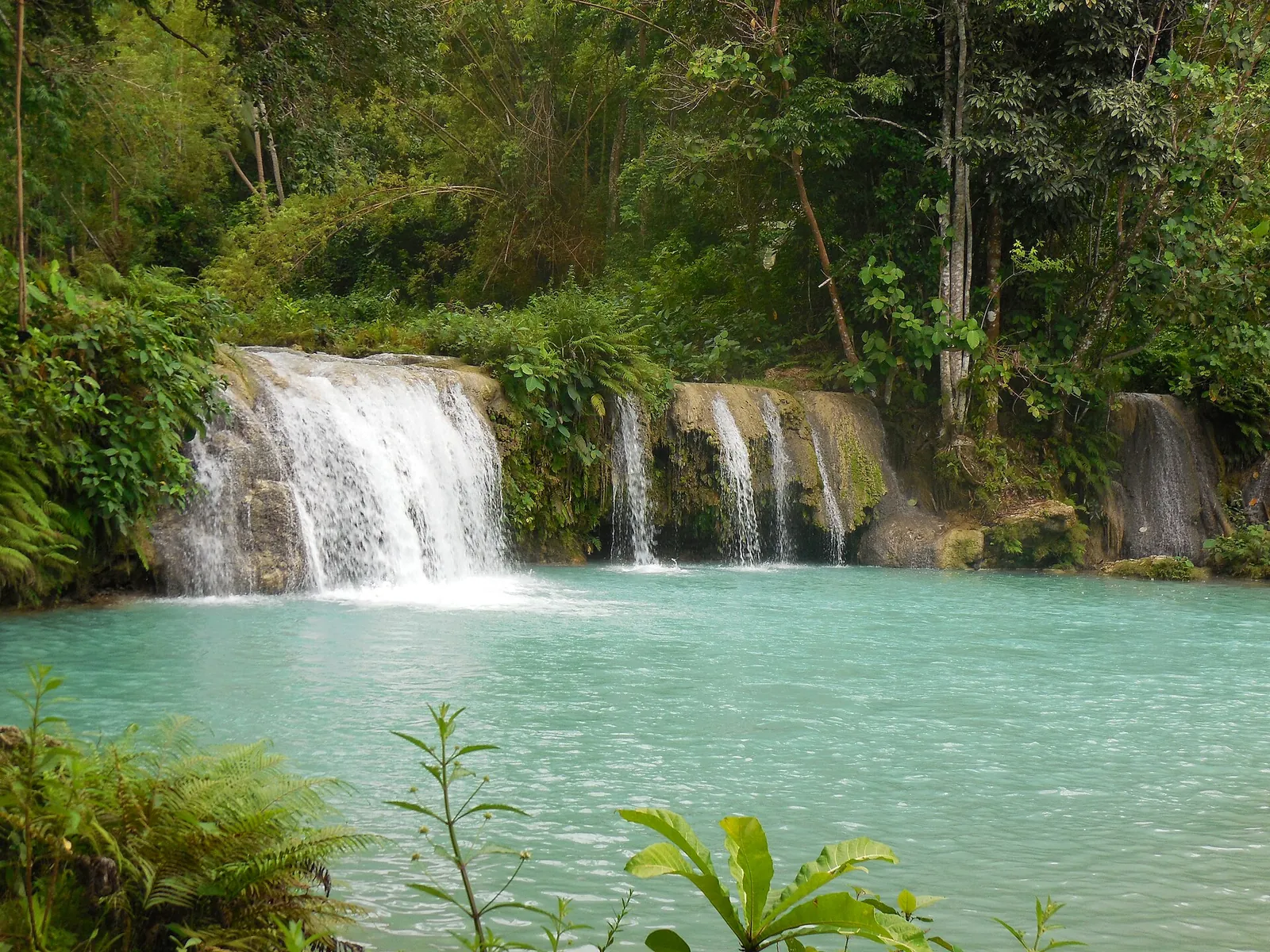Broad waterfalls and a turquoise pool at Cambugahay Falls in Lazi on Siquijor
