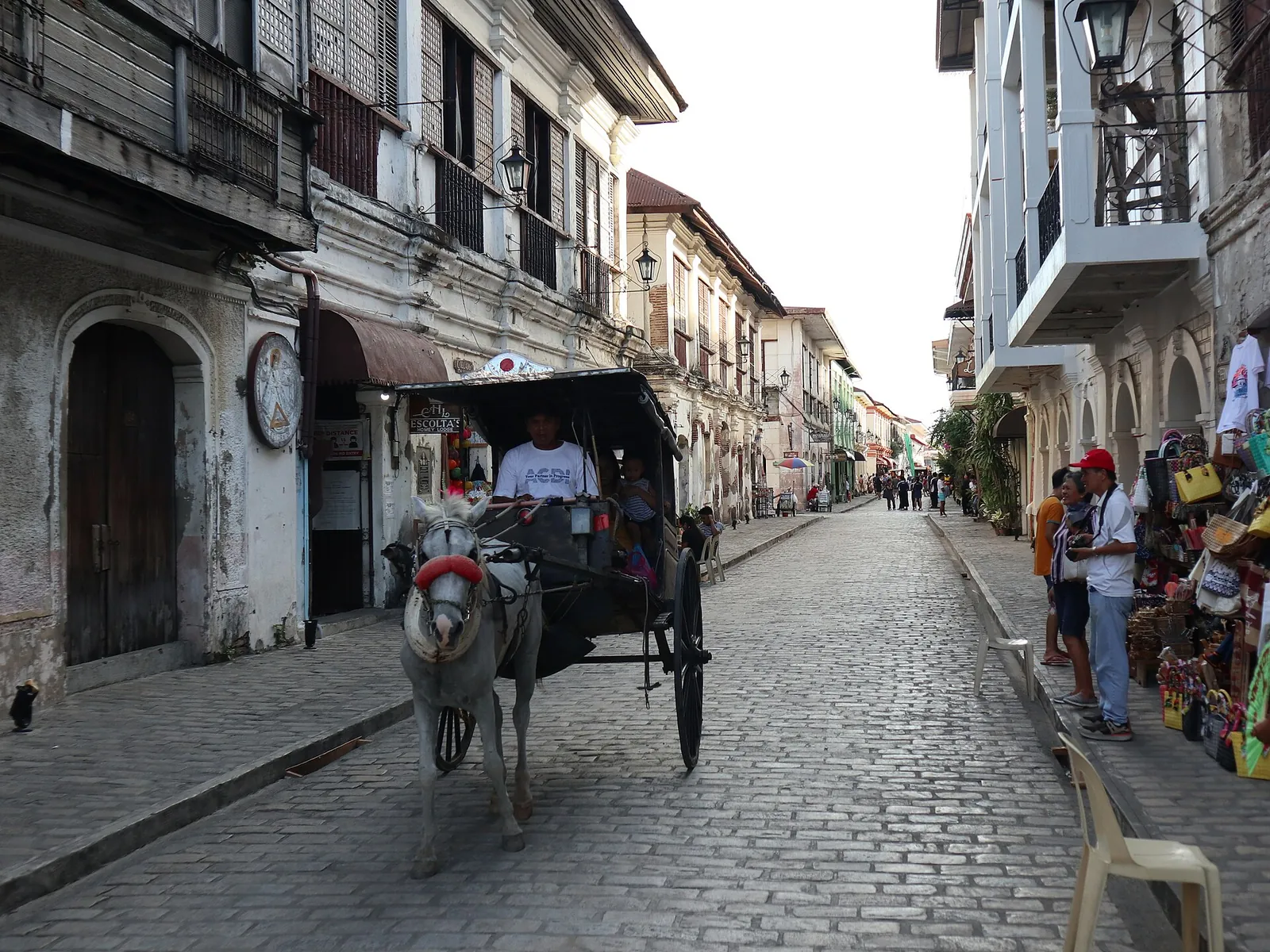 Horse-drawn carriage and pedestrians along heritage buildings in Vigan