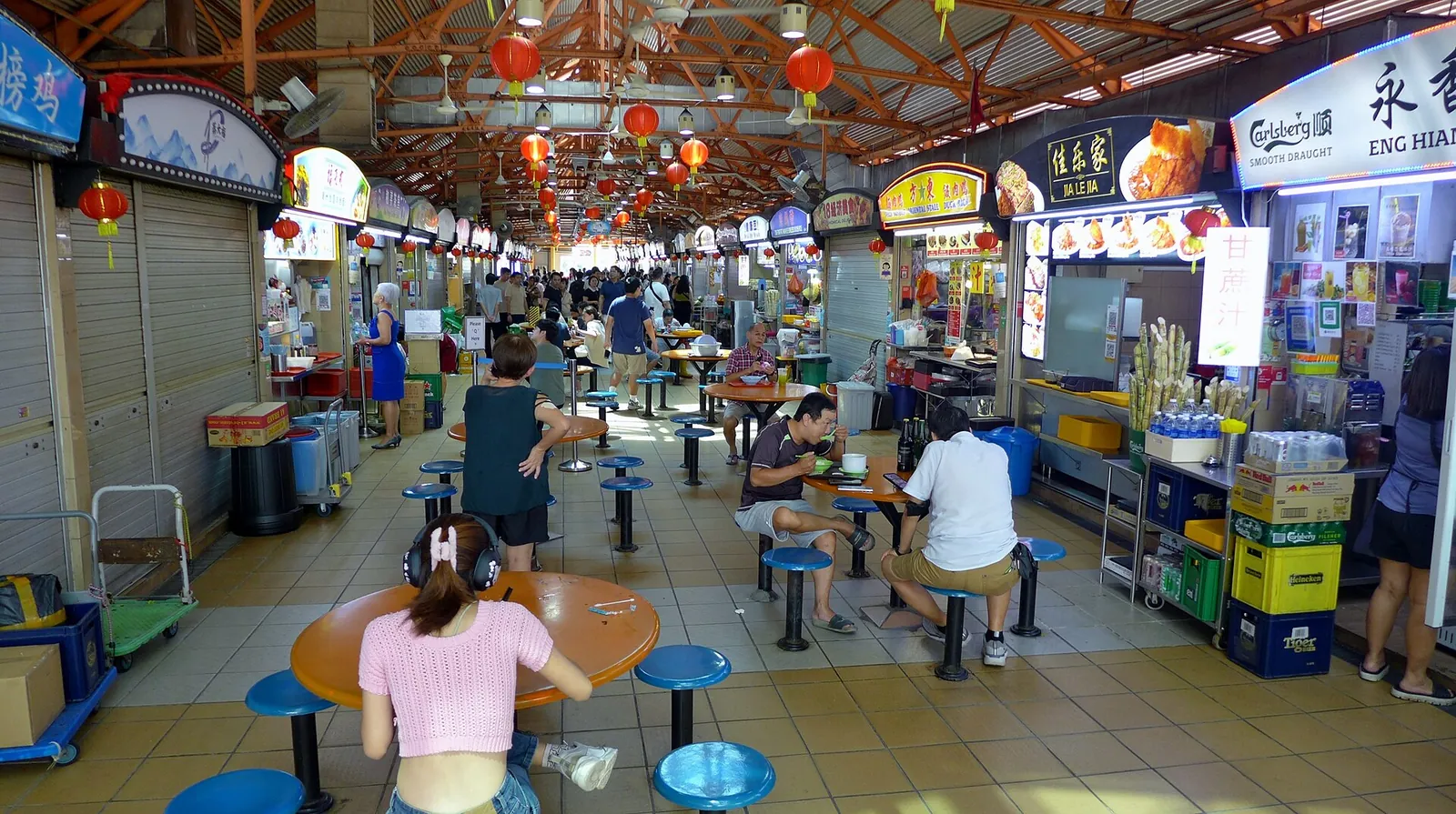 Oameni la masă și standuri alimentare în Maxwell Food Centre