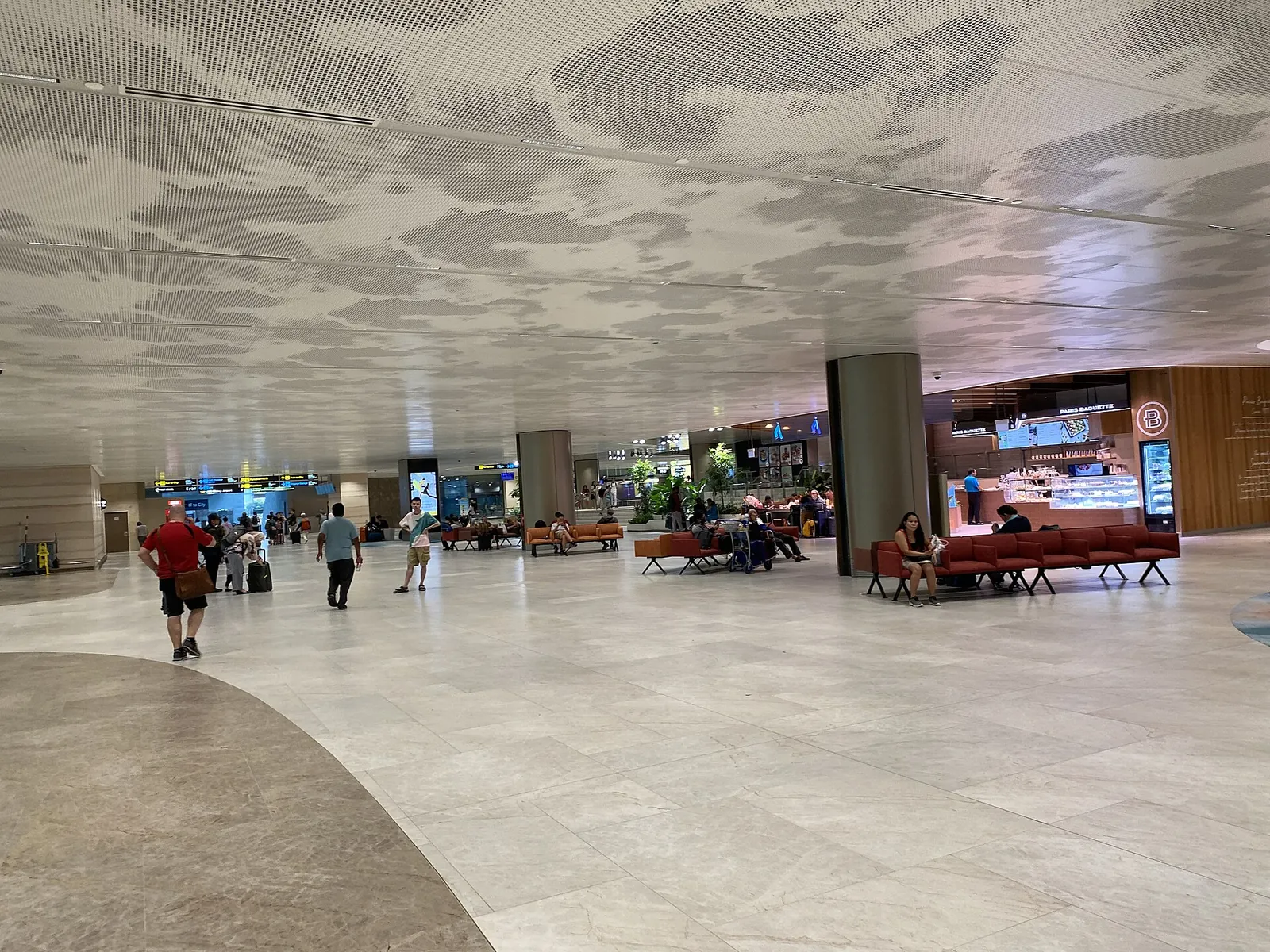 Passagers sous le plafond sculpté du Terminal 2 de Changi