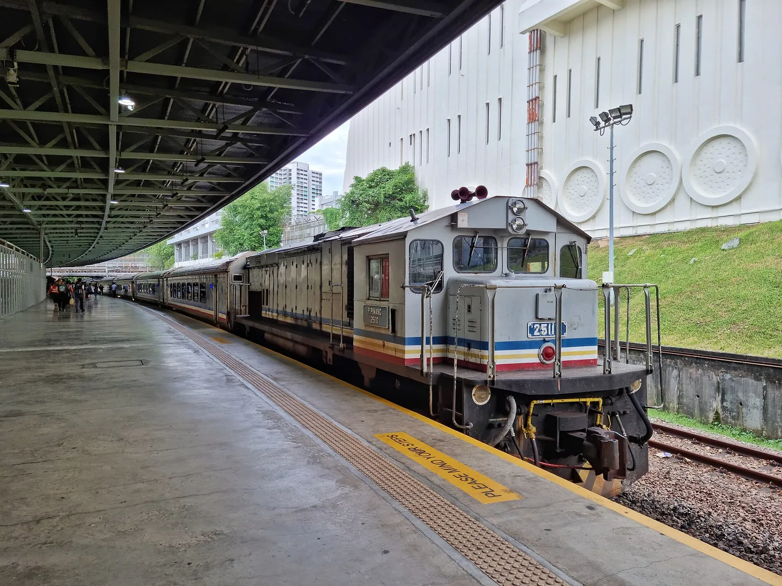 Locomotive et train voyageurs près du quai couvert de Woodlands Train Checkpoint à Singapour