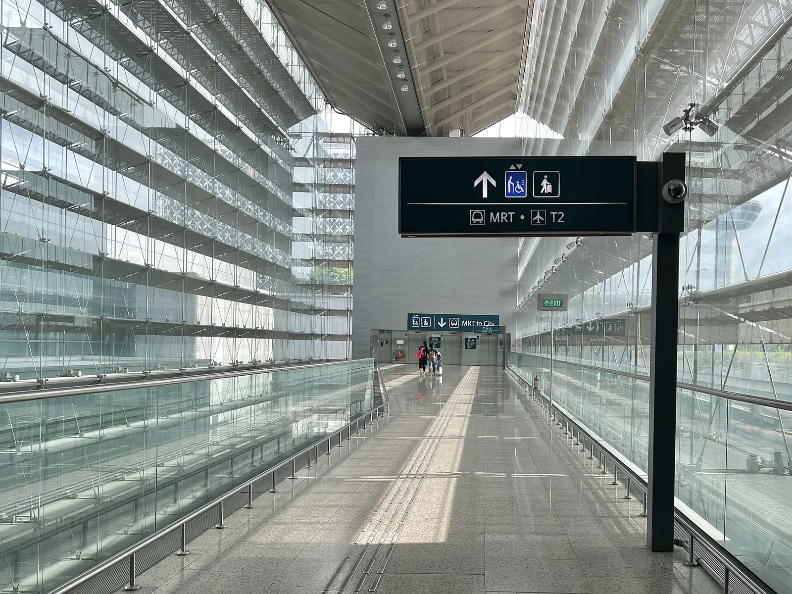 Gläserner Durchgang in Changi mit einem Schild zur MRT und zu Terminal 2