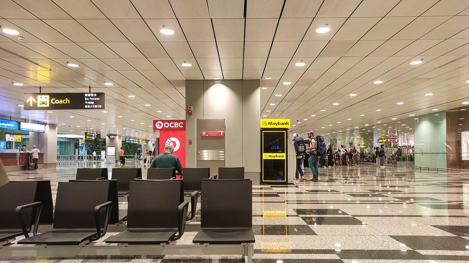 Ruhiger Sitzbereich und Schilder in einer Abflughalle am Flughafen Changi