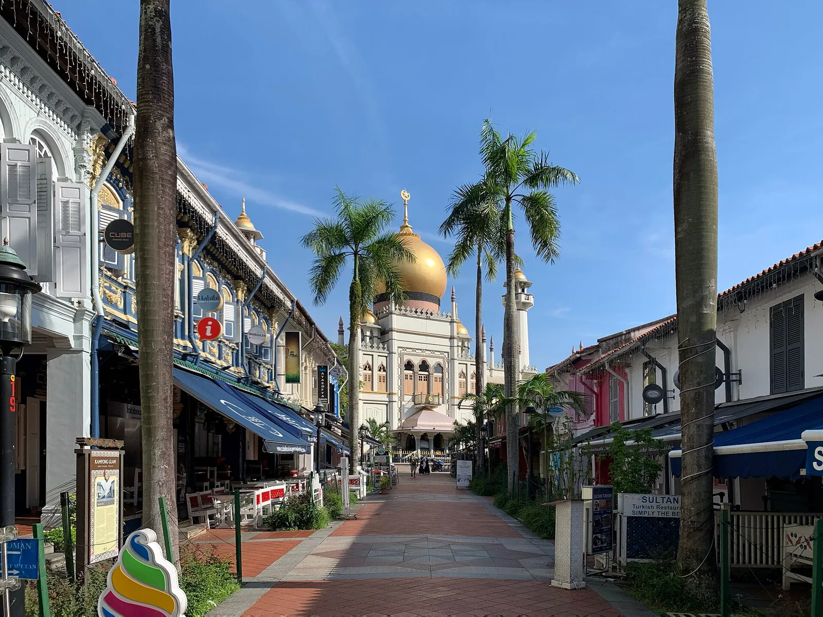 Sultan Mosque văzută de pe o străduță însorită în Kampong Glam