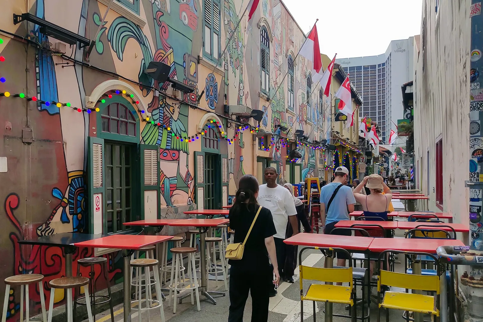 Fațade comerciale colorate și locuri de stat în aer liber pe Haji Lane