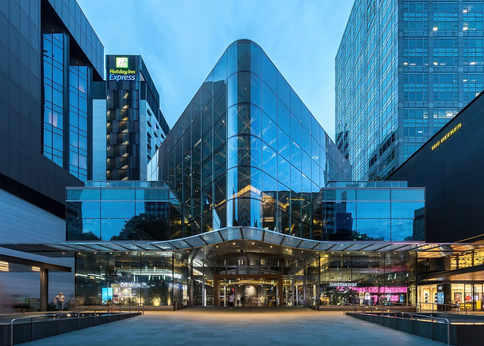 Glasfacade på et indkøbscenter på Orchard Road i den blå time