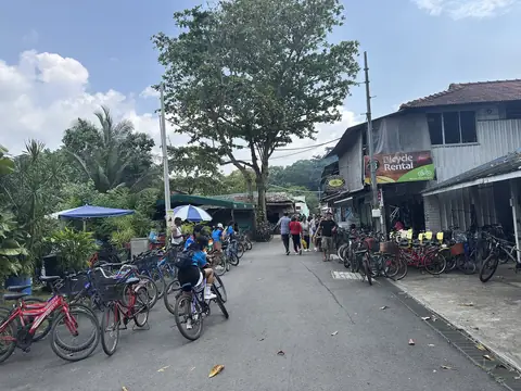 Biciclette e negozi del villaggio lungo una strada soleggiata di Pulau Ubin