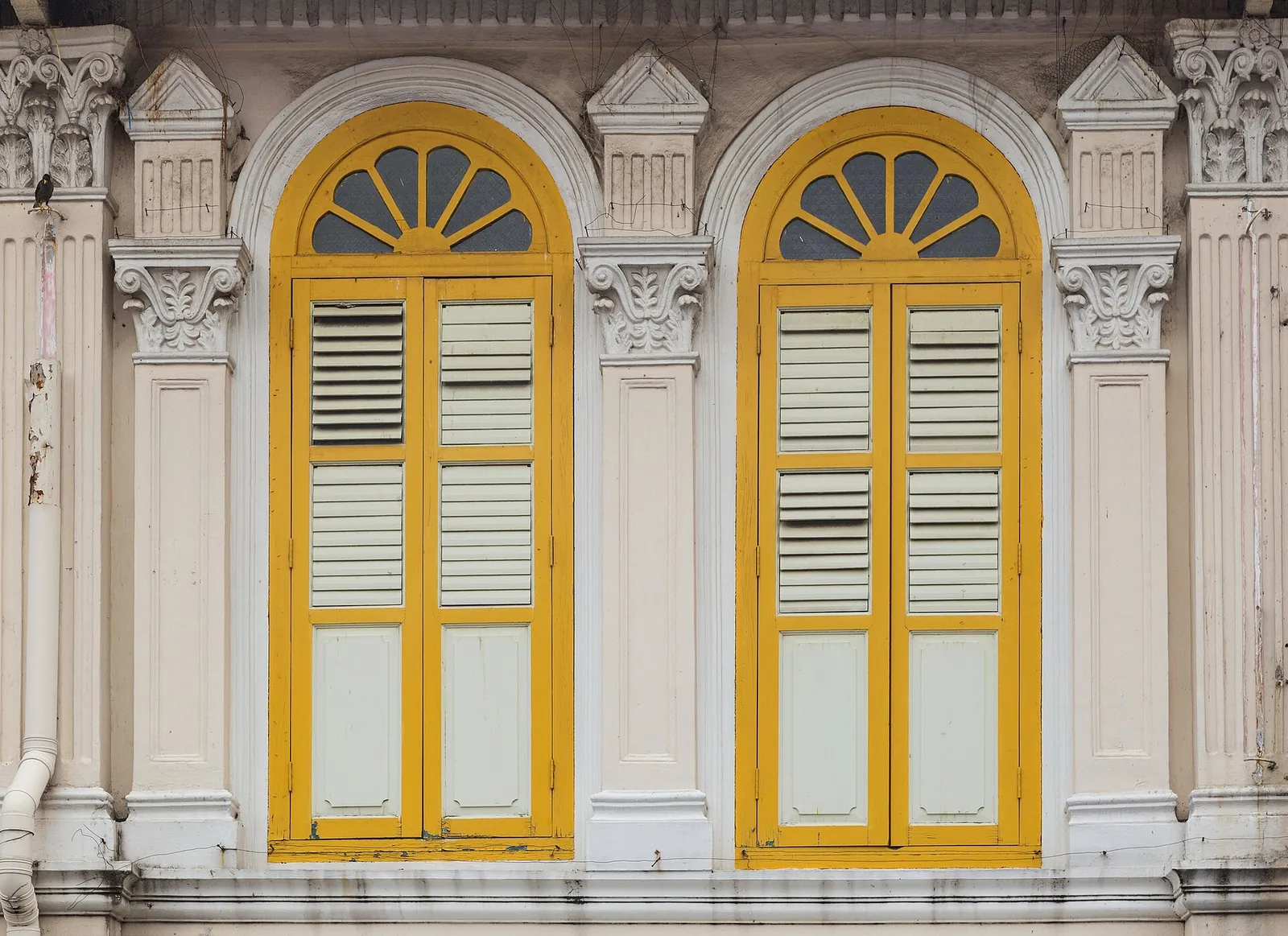 Gelbe Fensterläden in verzierten hellen Shophouse-Fassaden an der Kerbau Road in Singapur