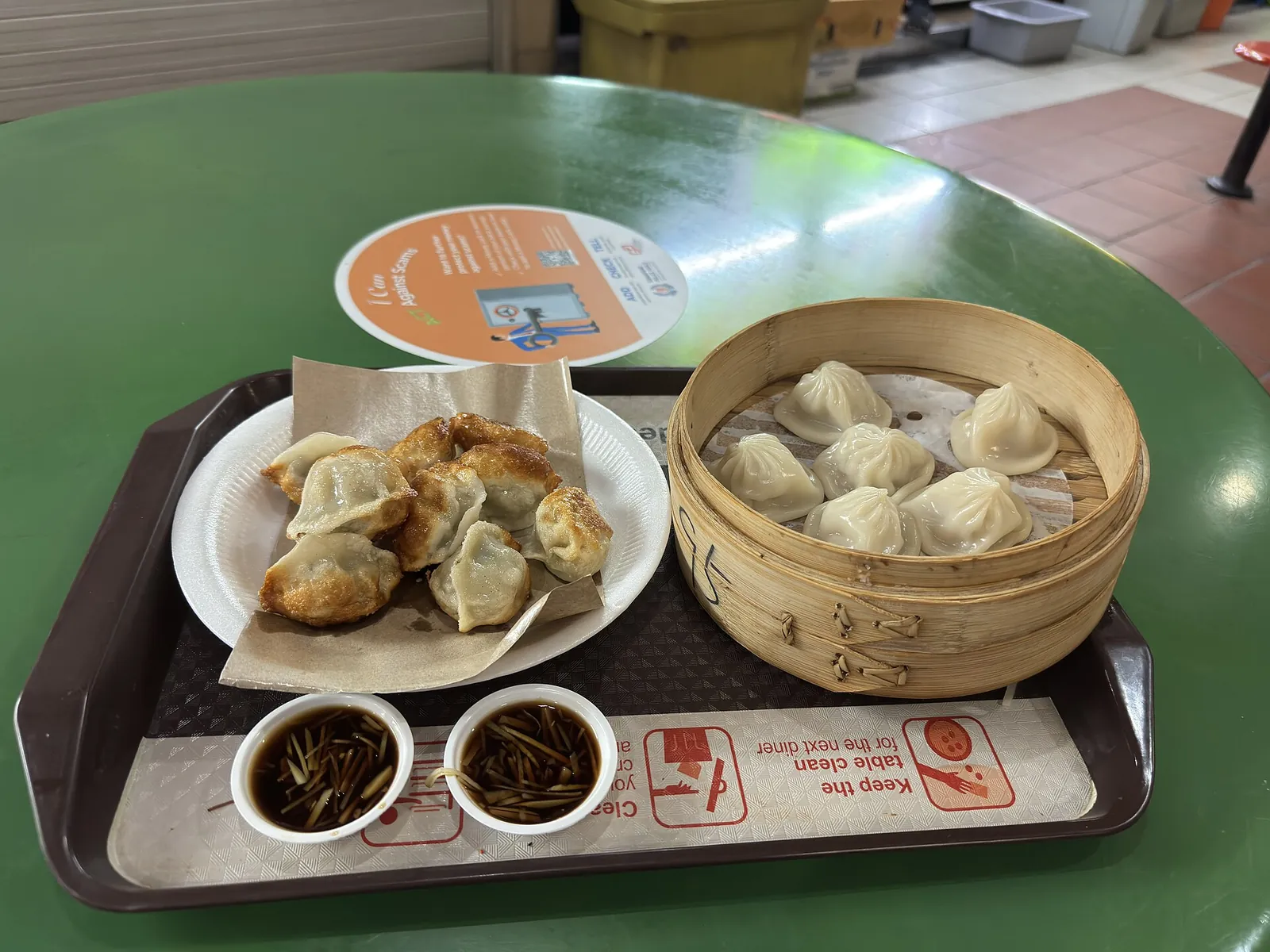 En bakke med dumplings og en bambusdamper med xiaolongbao på Maxwell Food Centre