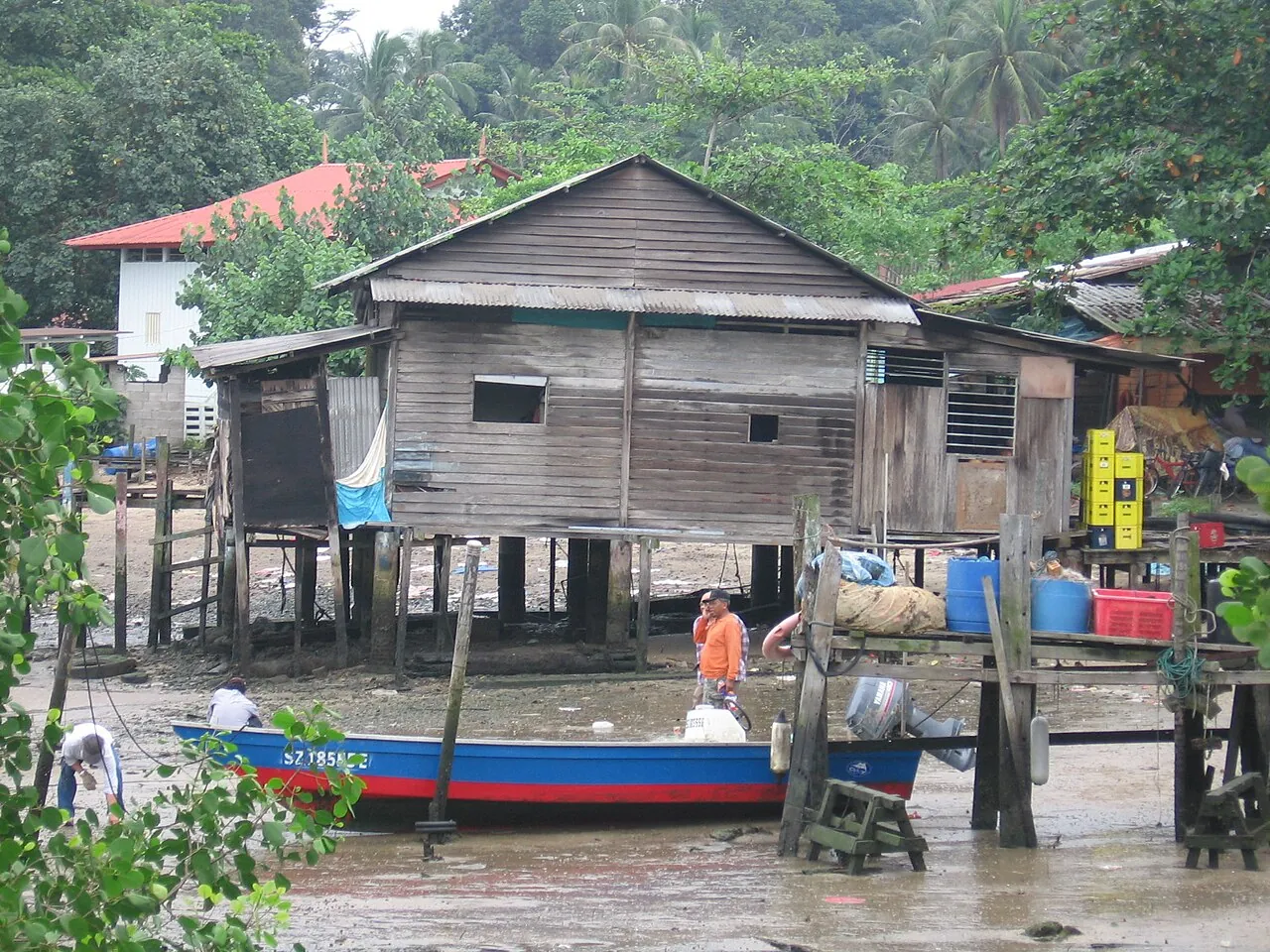 Træbygning ved vandet og en lille båd på Pulau Ubin i Singapore