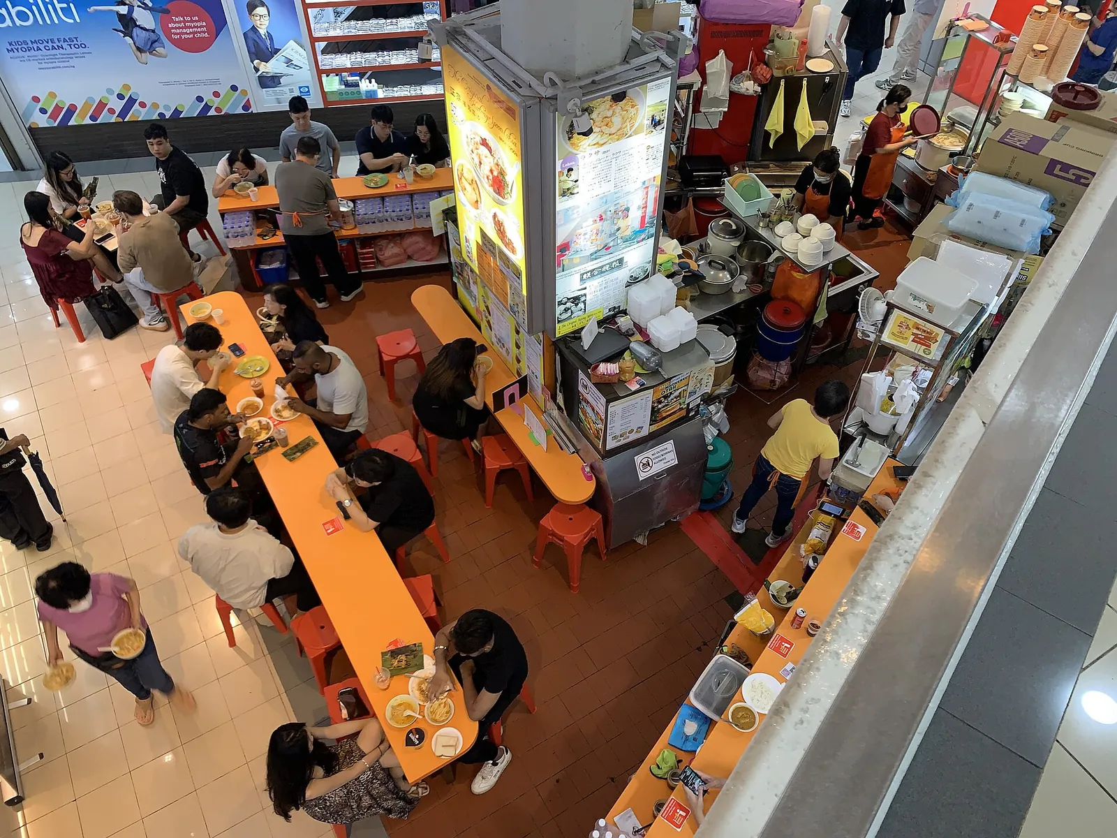 An overhead view of diners and a laksa stall in Queensway Shopping Centre in Singapore