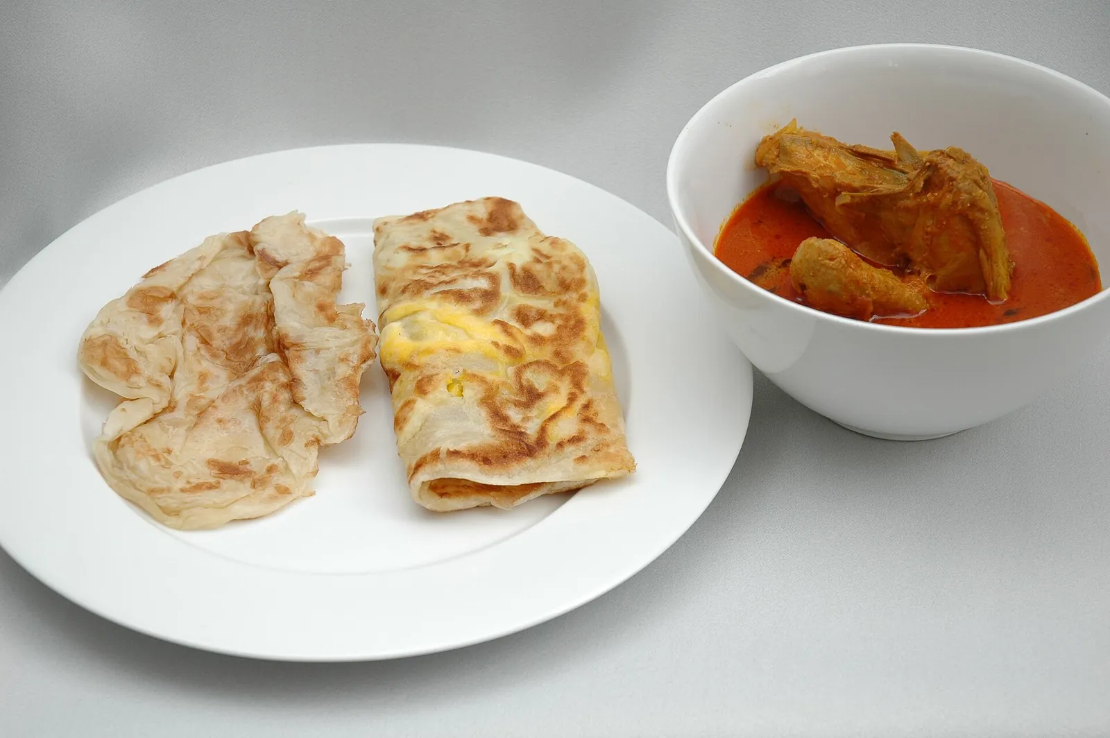 Obyčejná roti prata a vaječná prata s miskou kuřecího kari