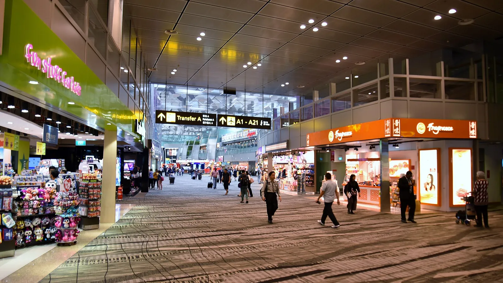 Negozi accanto al passaggio passeggeri con moquette in Changi Terminal 3