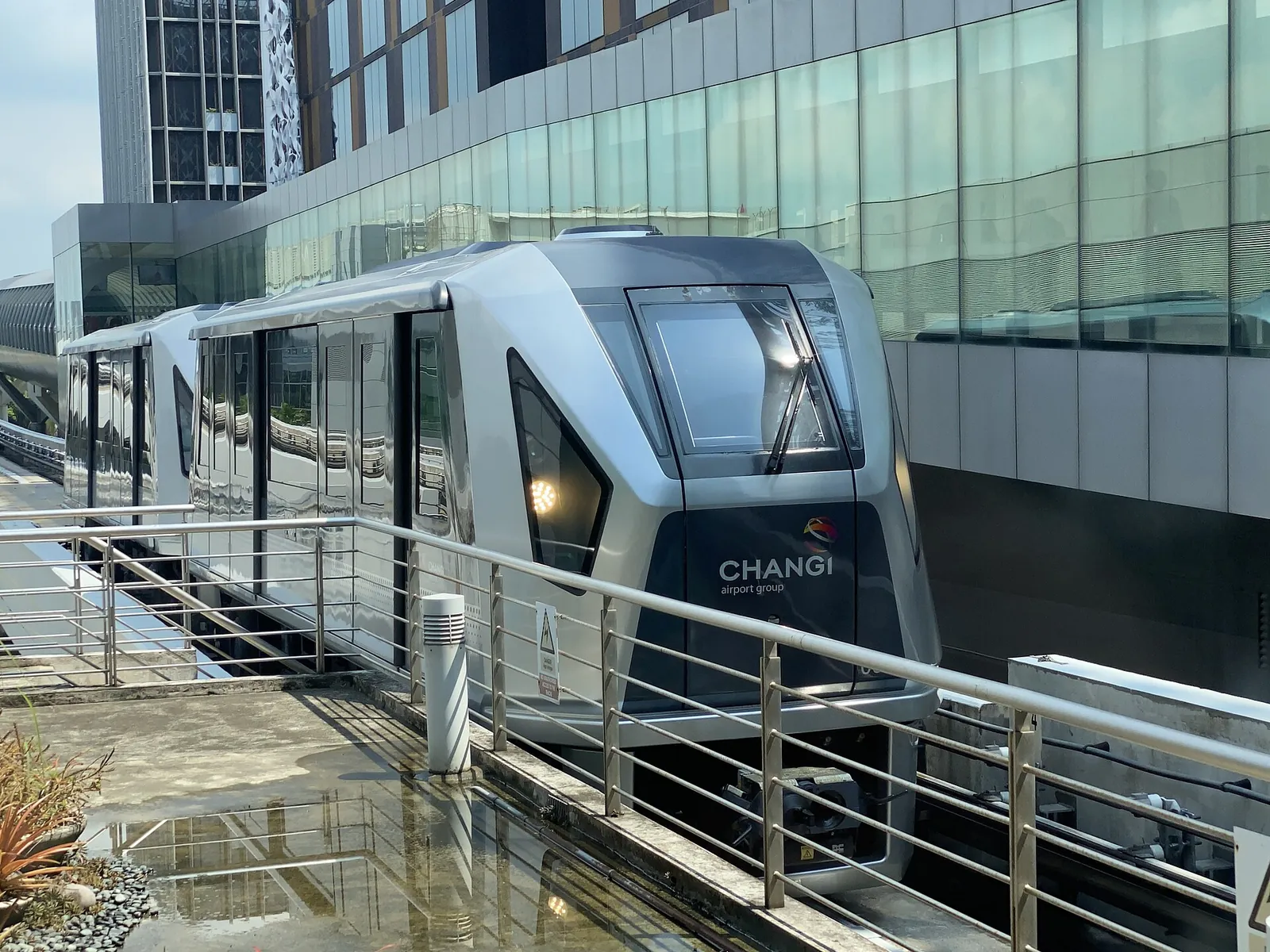 Changi Skytrain accanto a un edificio del terminal aeroportuale