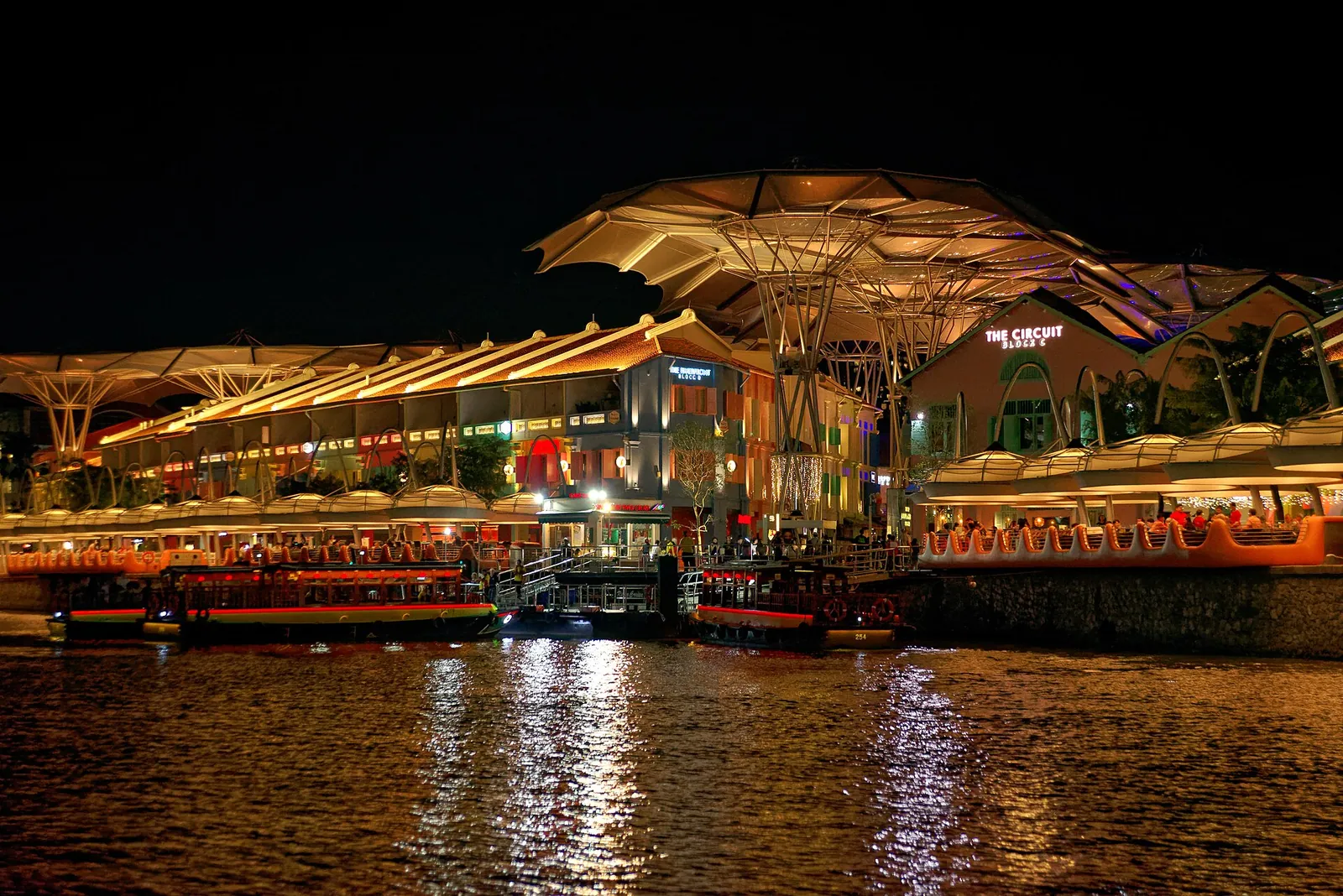 Opplyste restauranter og overbygd elvepromenade ved Clarke Quay