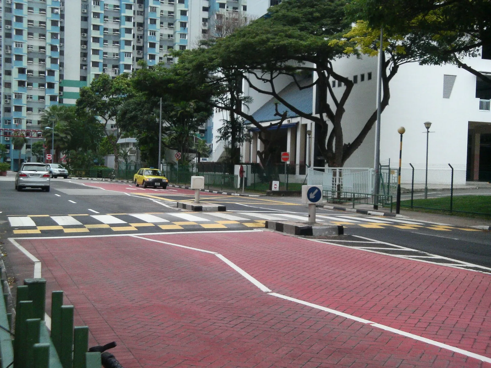 Ein erhöhter Zebrastreifen und Zufahrtsmarkierungen auf einer singapurischen Straße