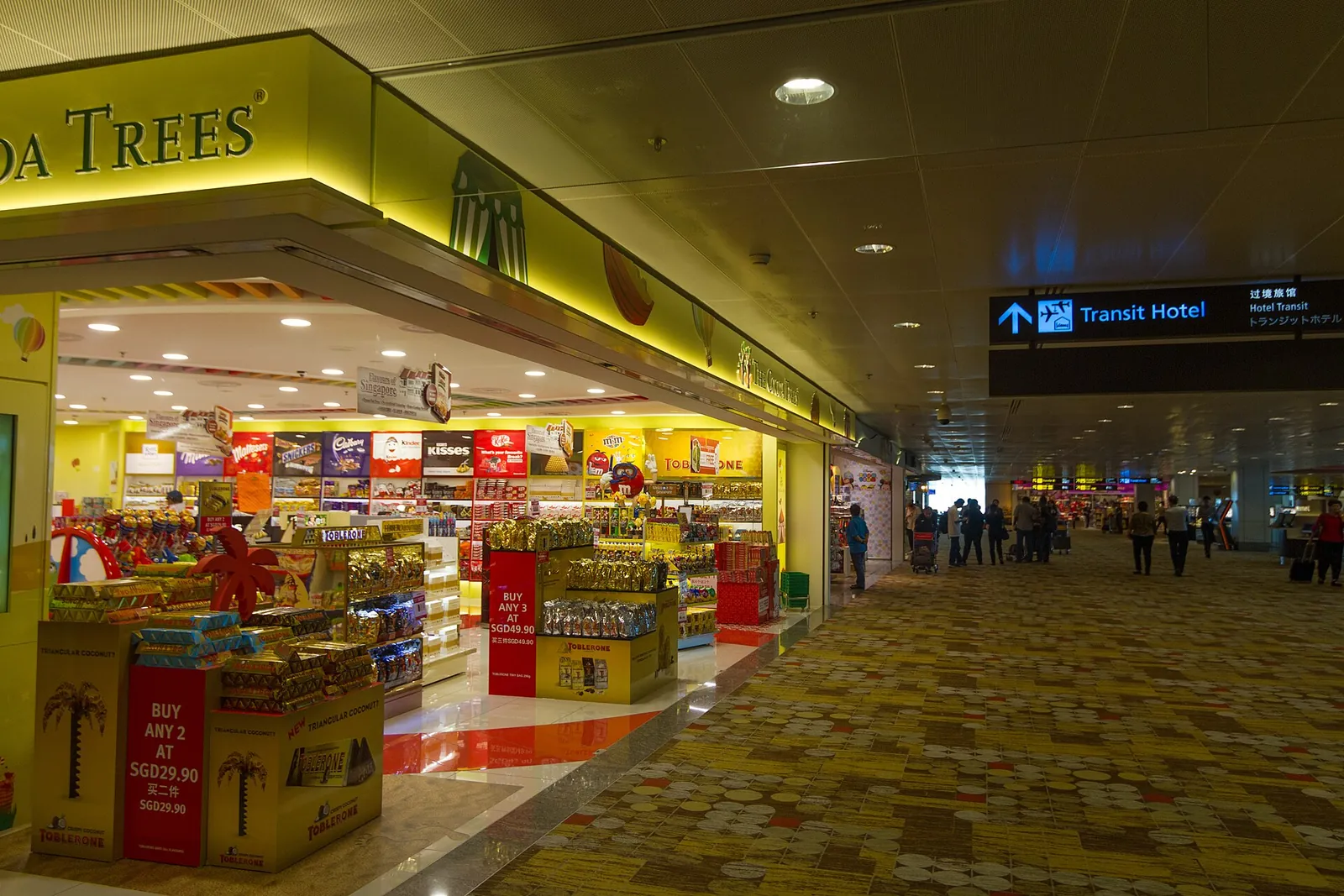 Tienda aeroportuaria iluminada y pasillo en el aeropuerto de Changi, Singapur