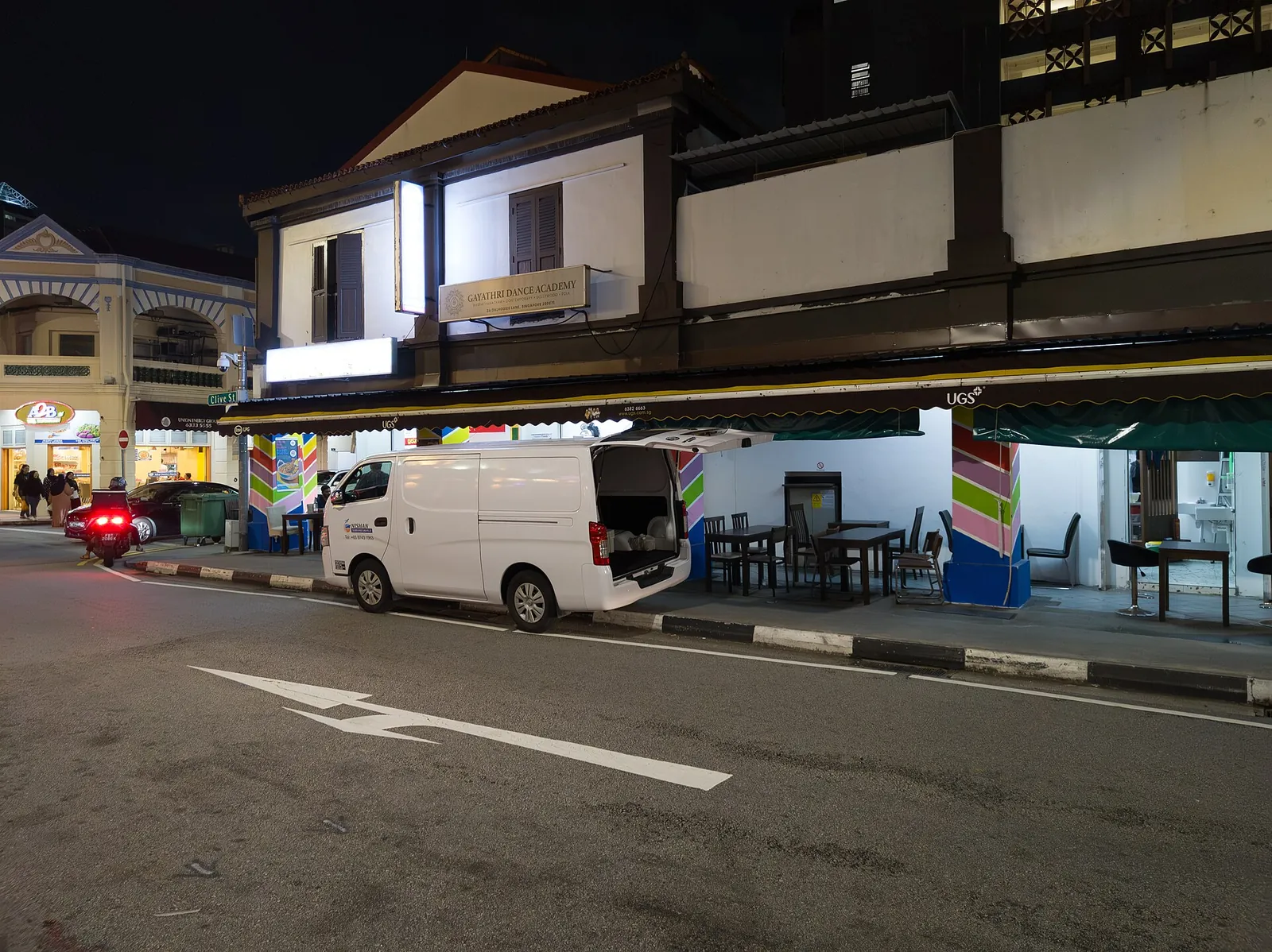 Tiendas iluminadas y calle de Little India de noche para ilustrar la orientación urbana