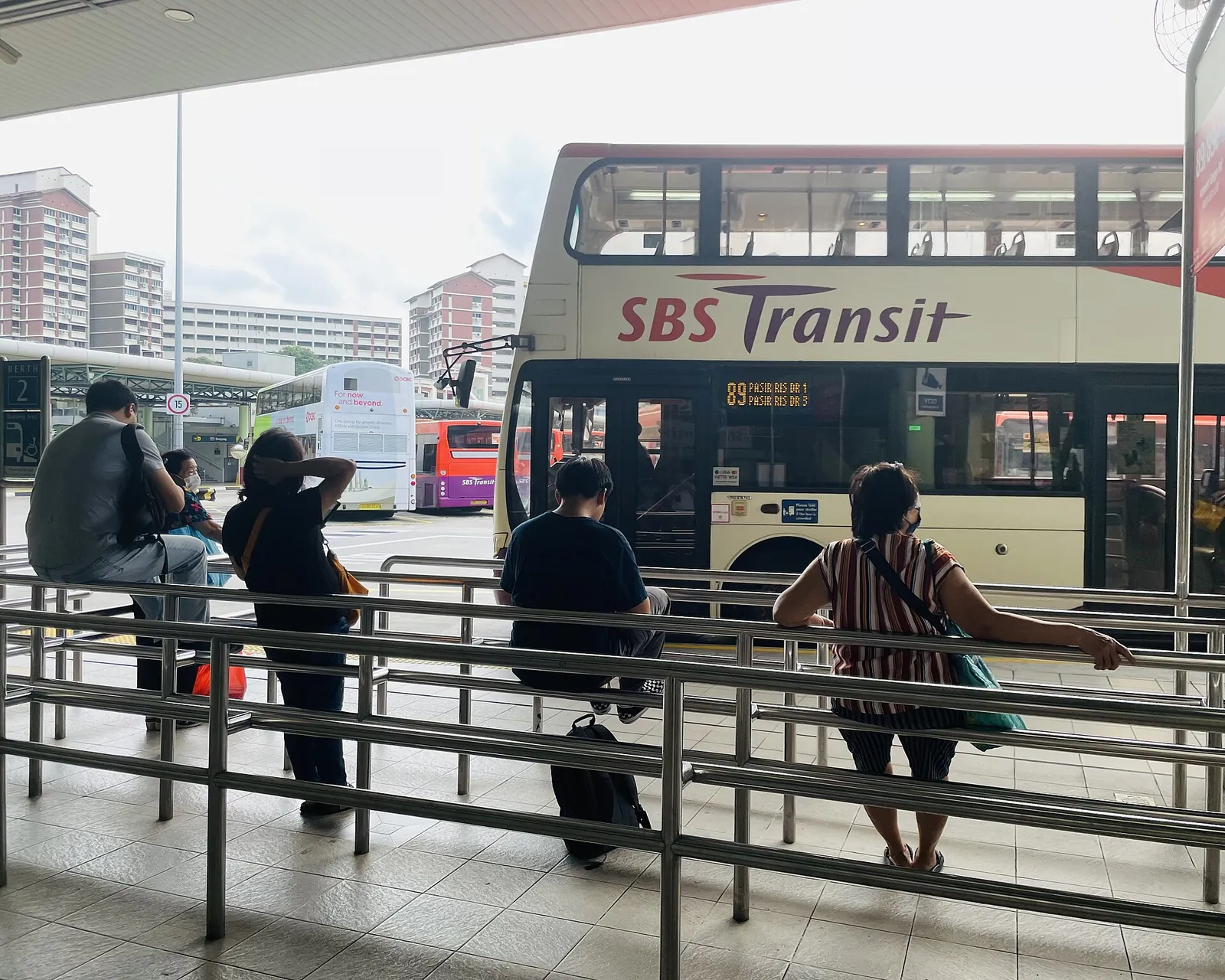 Passagiers wachten naast een dubbeldekkerbus bij Hougang Central Bus Interchange in Singapore