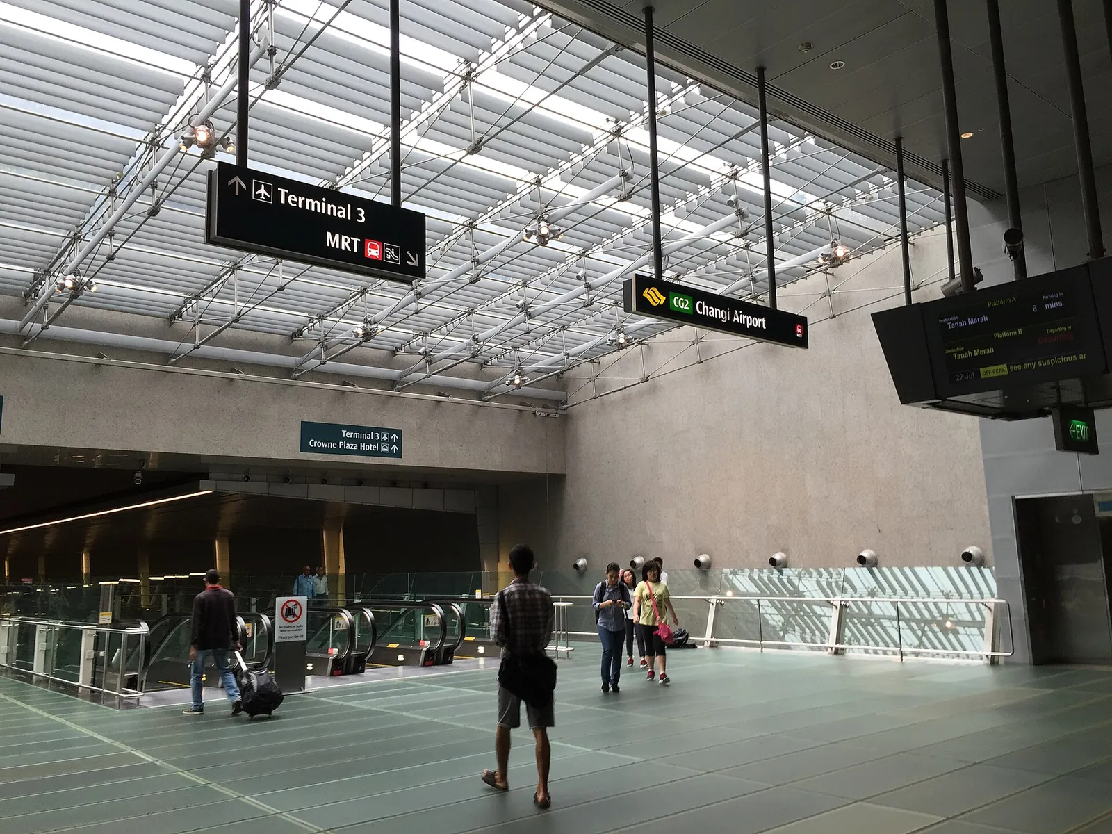 Passagiers onder een glazen dak bij uitgang A van MRT-station Changi Airport