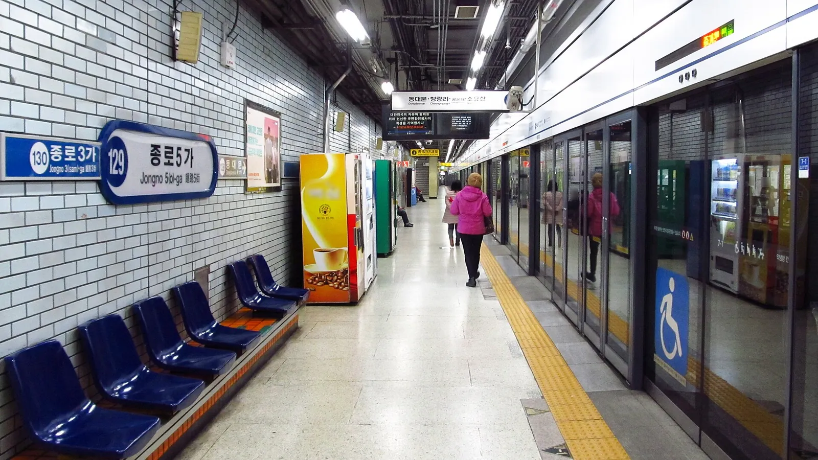 Platform at Jongno 5-ga Station on Seoul Subway Line 1 with platform screen doors, blue seats and a wheelchair symbol on one door