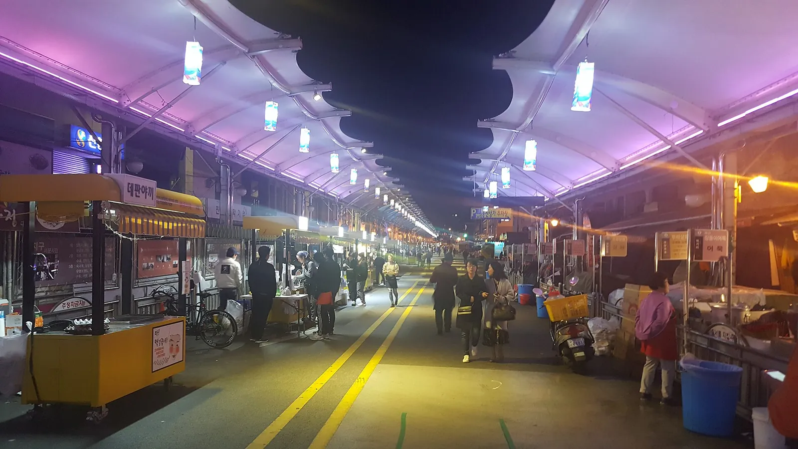 Lit food stalls under a canopy at Seomun Night Market in Daegu in the evening