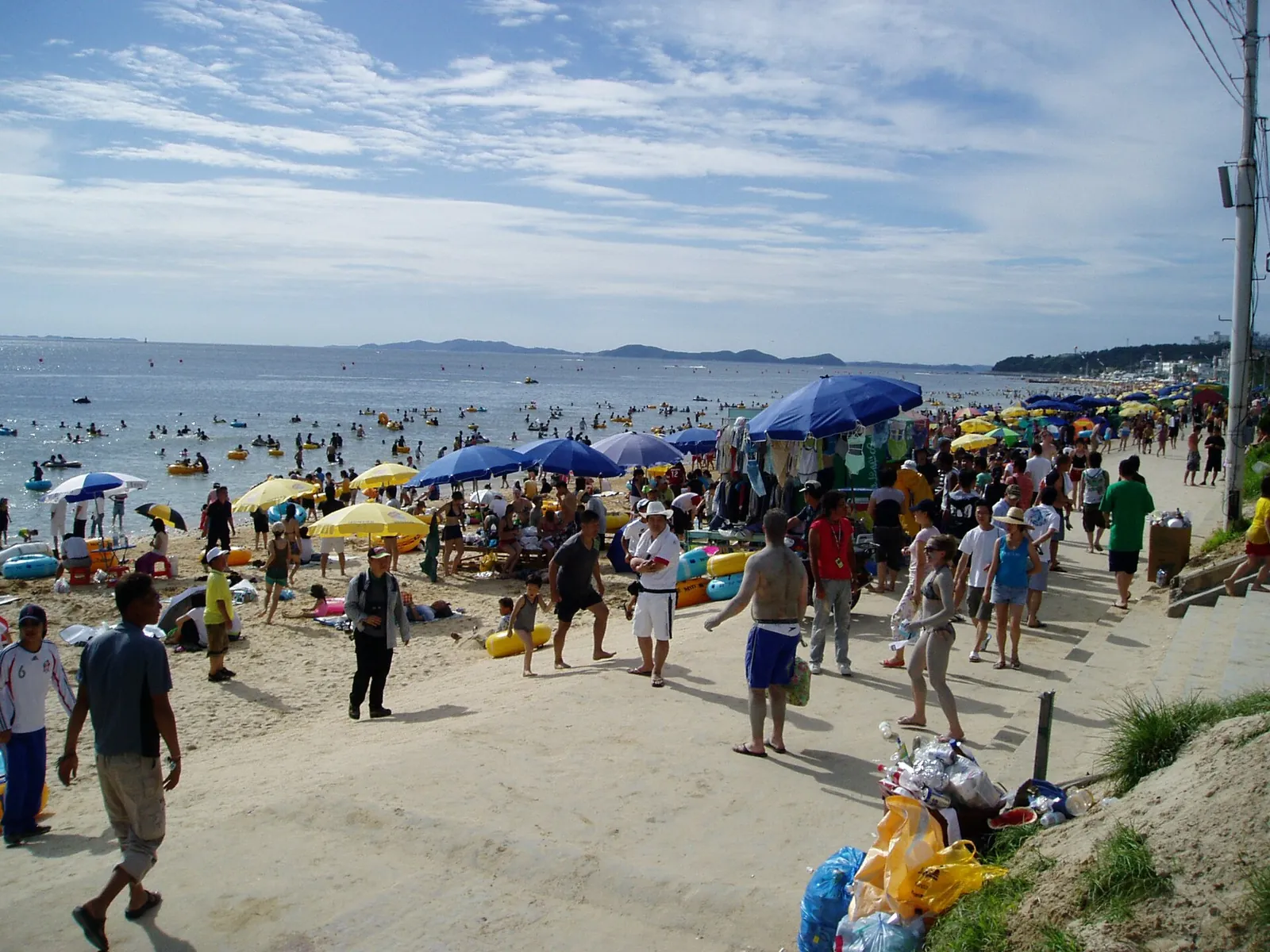 Crowds, beach umbrellas and swimmers on the sand at Daecheon Beach in Boryeong during the Mud Festival