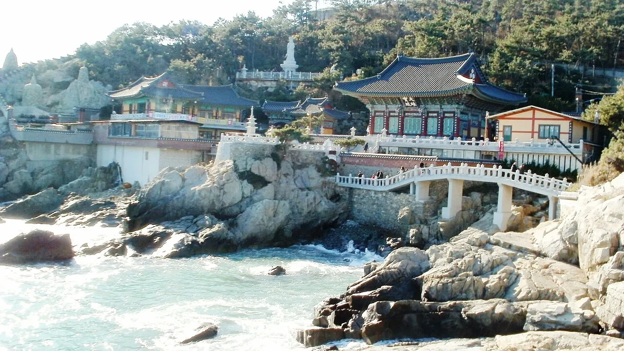 Haedong Yonggungsa Temple's halls and stone bridge on the rocky shoreline above the sea in Busan