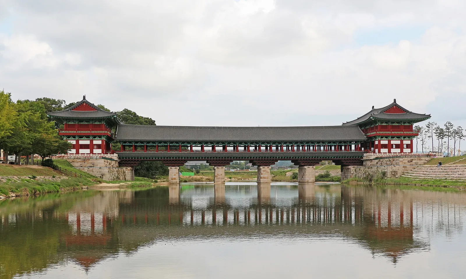 The covered wooden Woljeonggyo Bridge with its two gate pavilions reflected in the Namcheon stream in Gyeongju