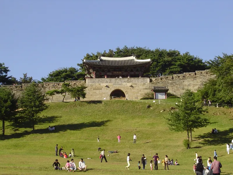 Gongnammun, the south gate of Sangdangsanseong Fortress in Cheongju, with its gate tower above a grassy slope and visitors on the lawn