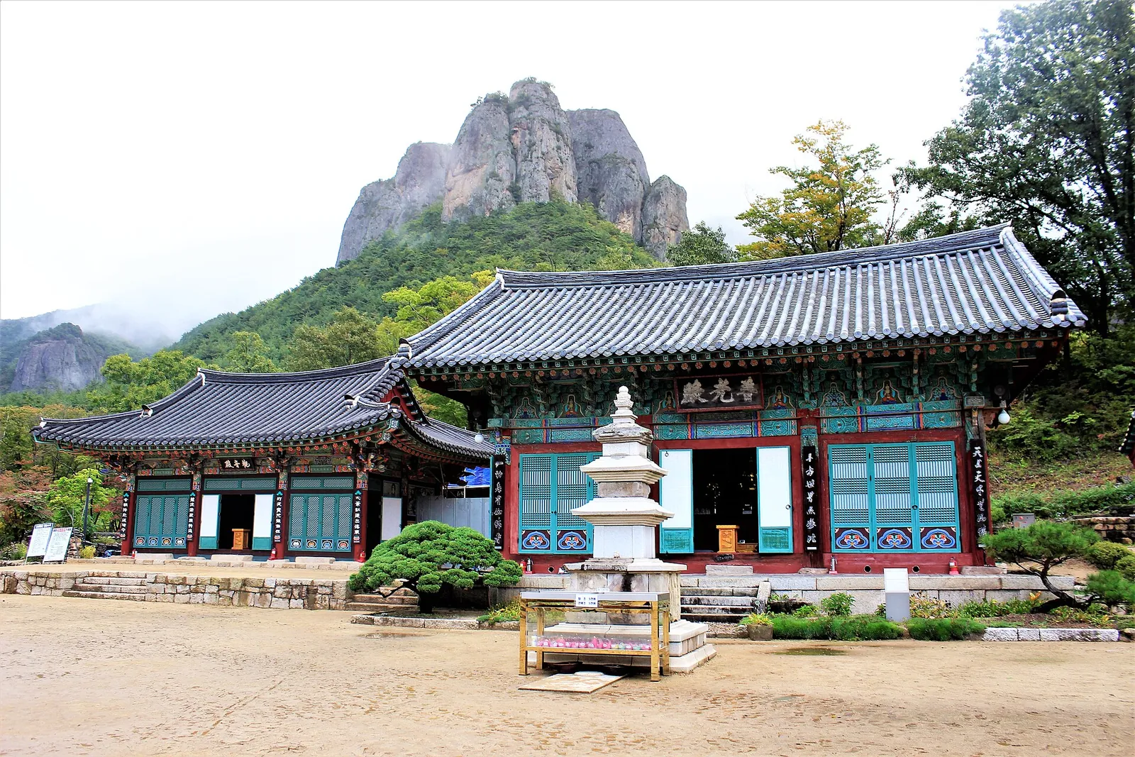 Daejeonsa Temple's main hall and stone pagoda with the rock peaks of Juwangsan rising behind