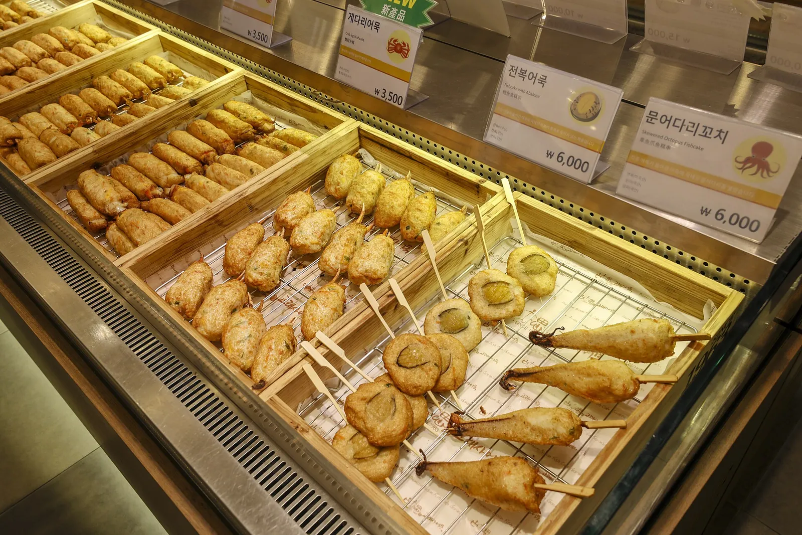 Trays of Busan fishcakes on skewers and in many shapes in a shop display at Goraesa in Haeundae